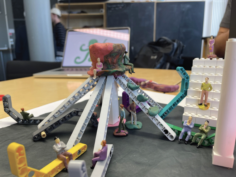 Prototype 2 — clay and LEGO combined, with miniature figures on the tentacles and benches