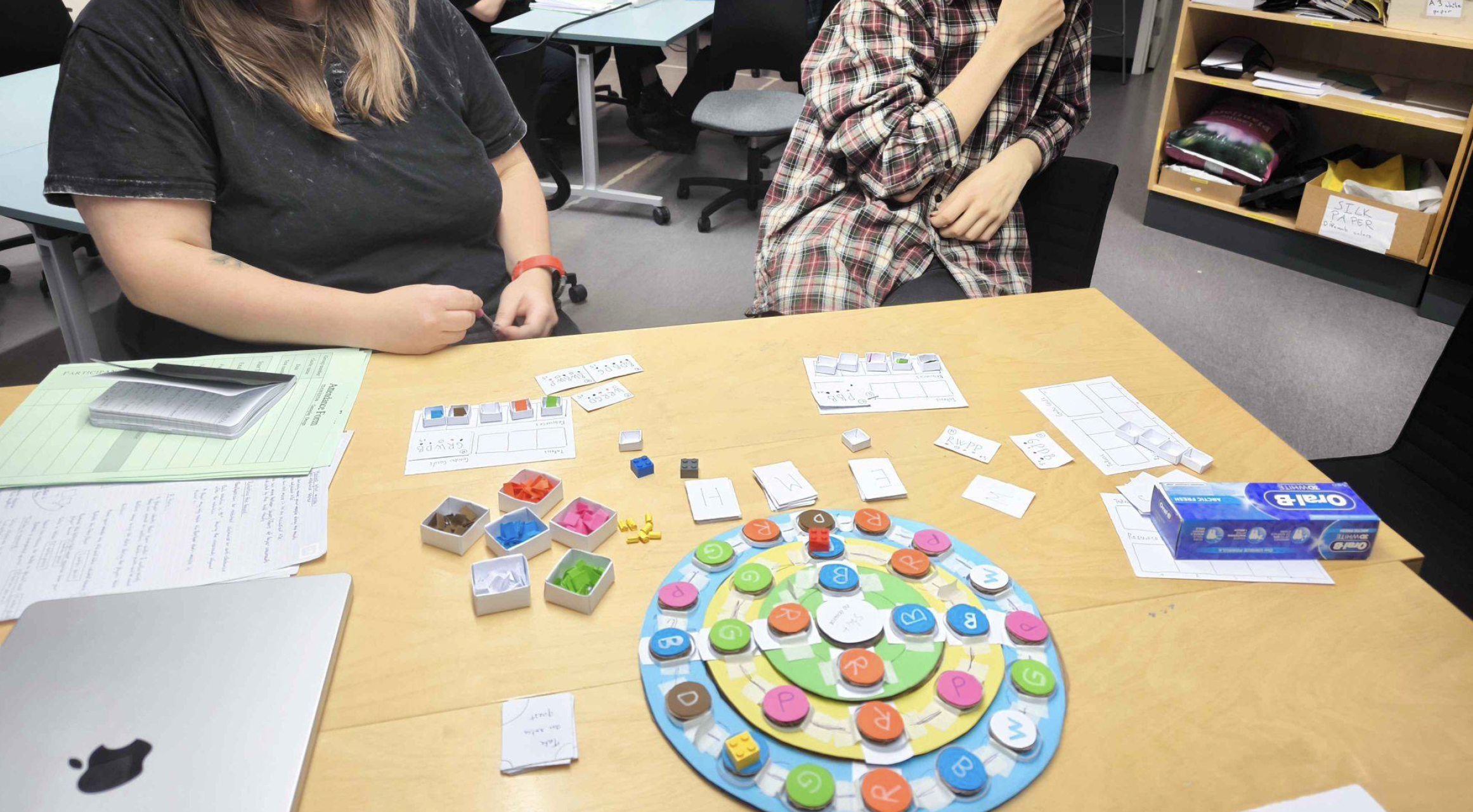 Testers reviewing an attendance form beside the board during a playtesting session