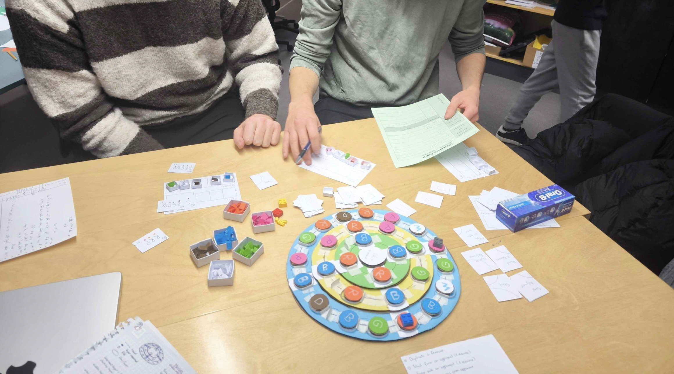 Two testers taking notes on cards next to the board during a session